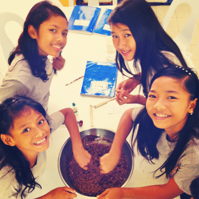 Young girls at a table making Snickers cookies.