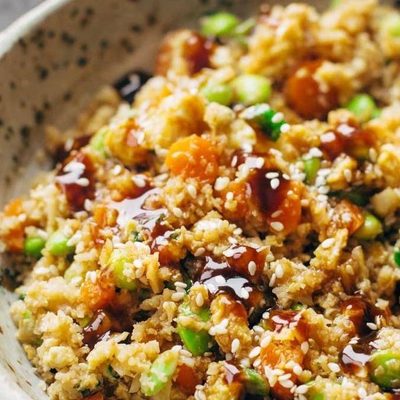 Cauliflower fried rice in a bowl with chopsticks.