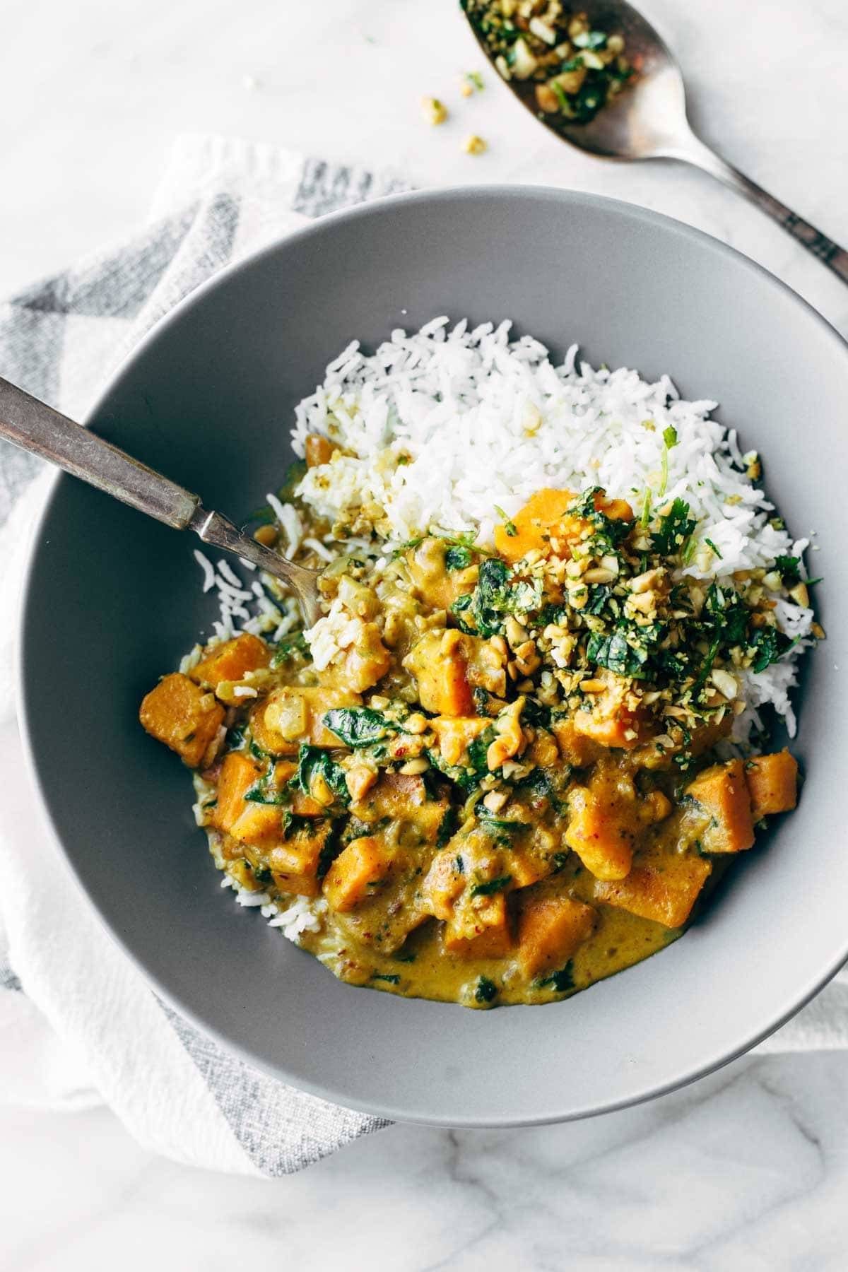 Sweet potato curry with rice in a bowl and with a spoon.